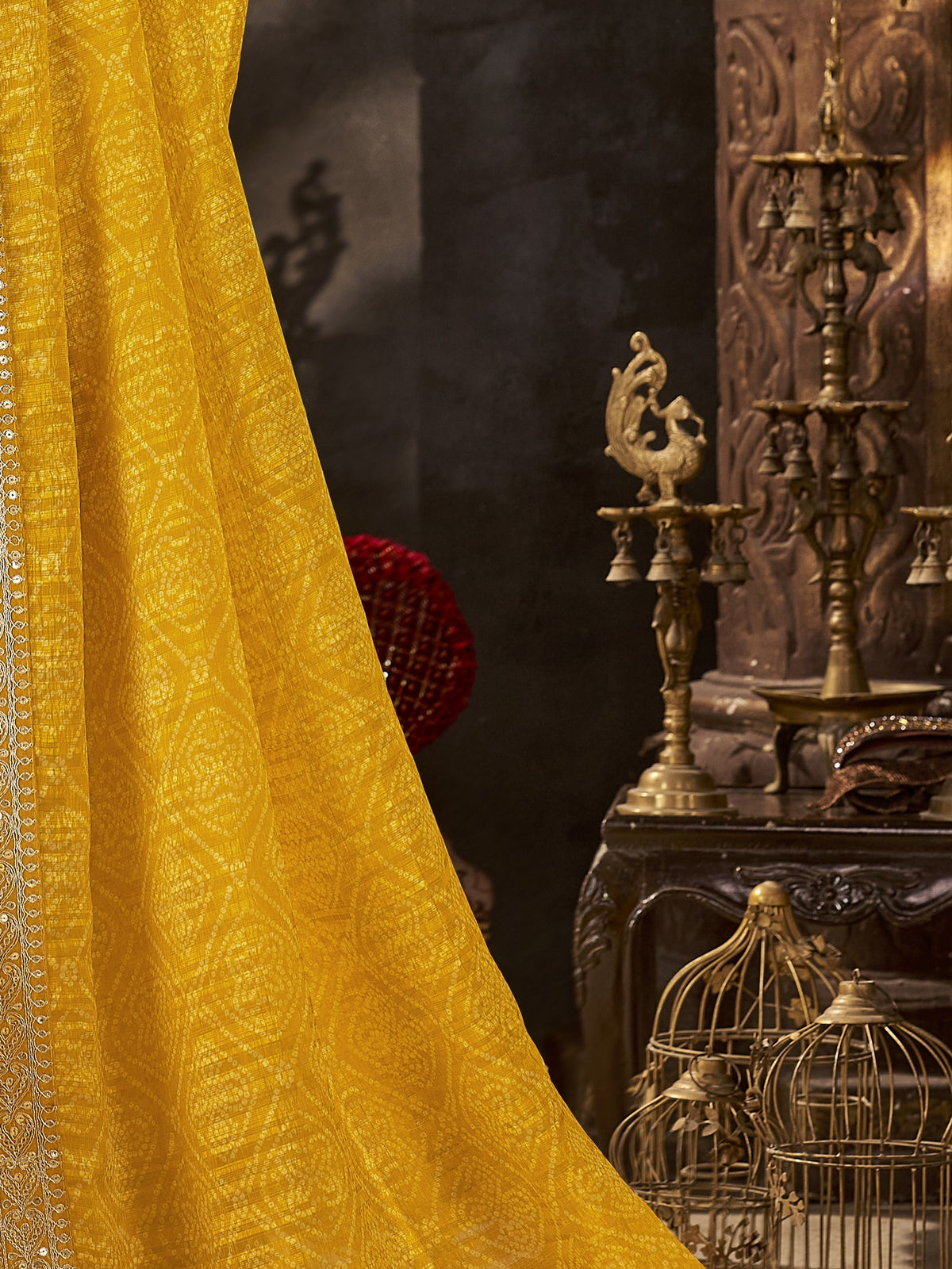 Pallu detail of yellow chiffon saree showing bandhani tie-dye dot work and embellished border