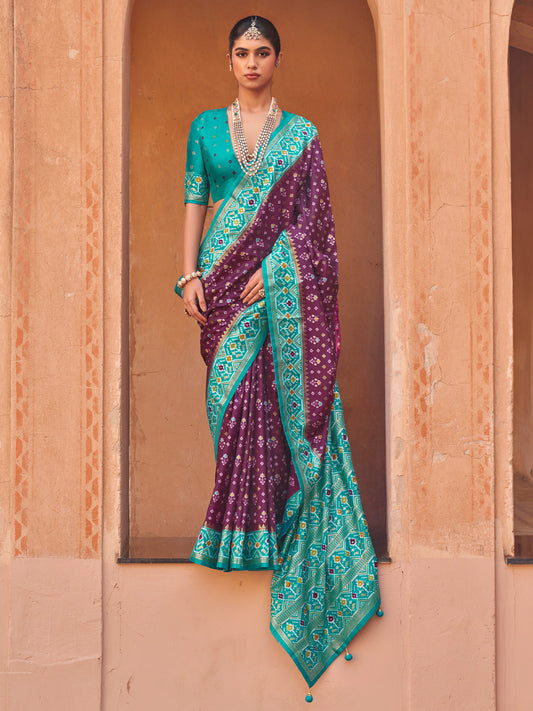 Woman wearing purple silk blend saree with ikat resist-dyed pattern and turquoise blue blouse