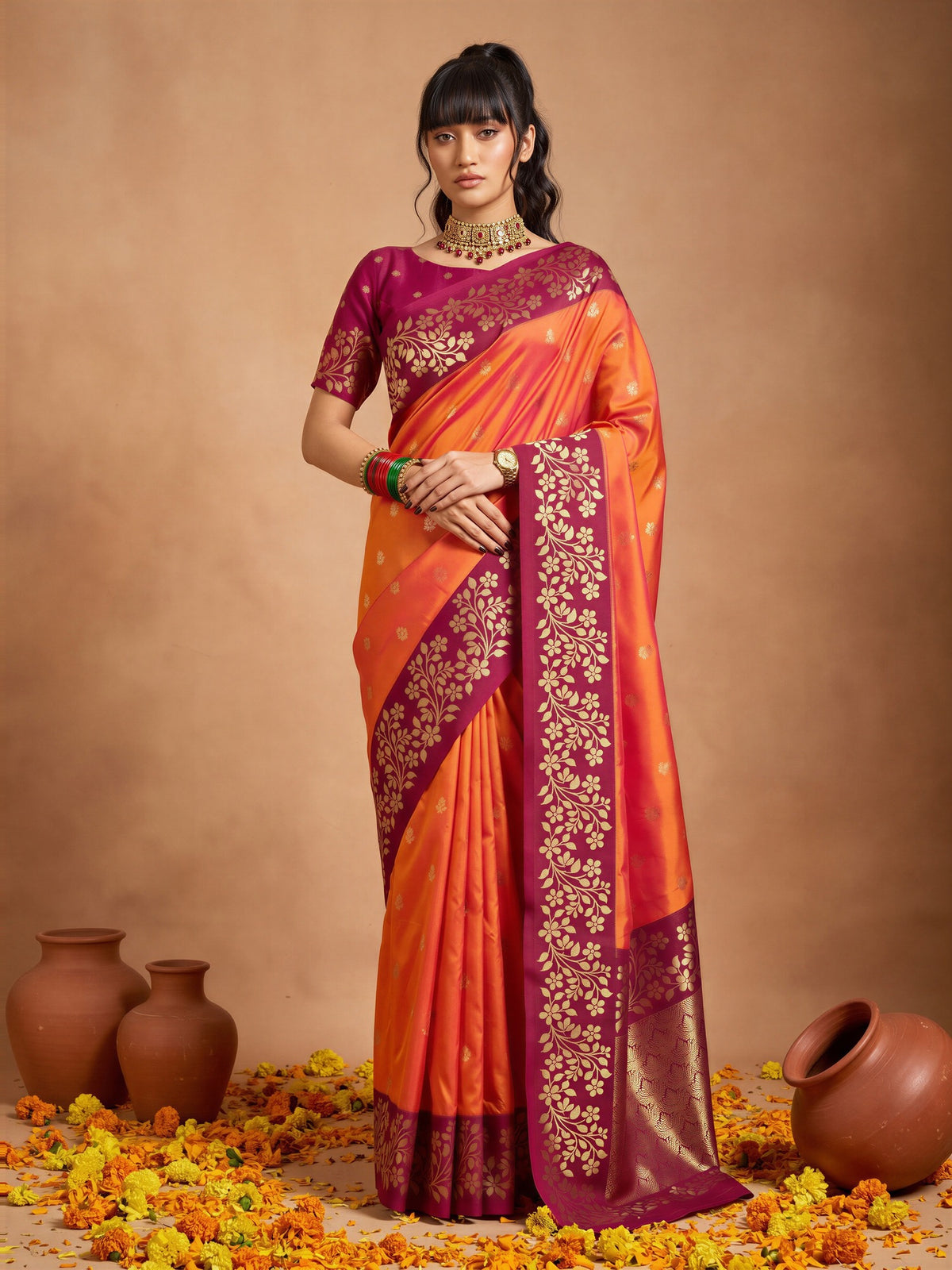 Woman wearing orange cotton blend saree with all-over floral design and magenta blouse