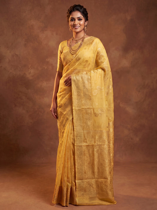 Woman wearing yellow silk blend saree with zari butta (metallic motif) work and yellow blouse