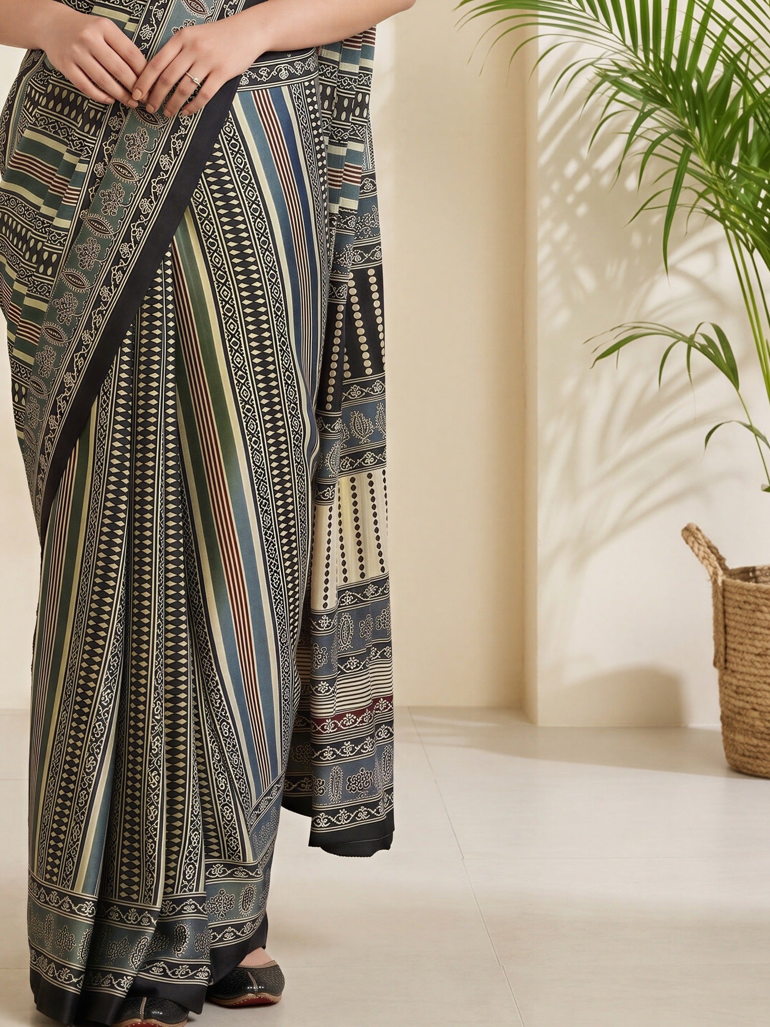 Pallu detail of grey satin saree showing traditional indian motif work and printed border