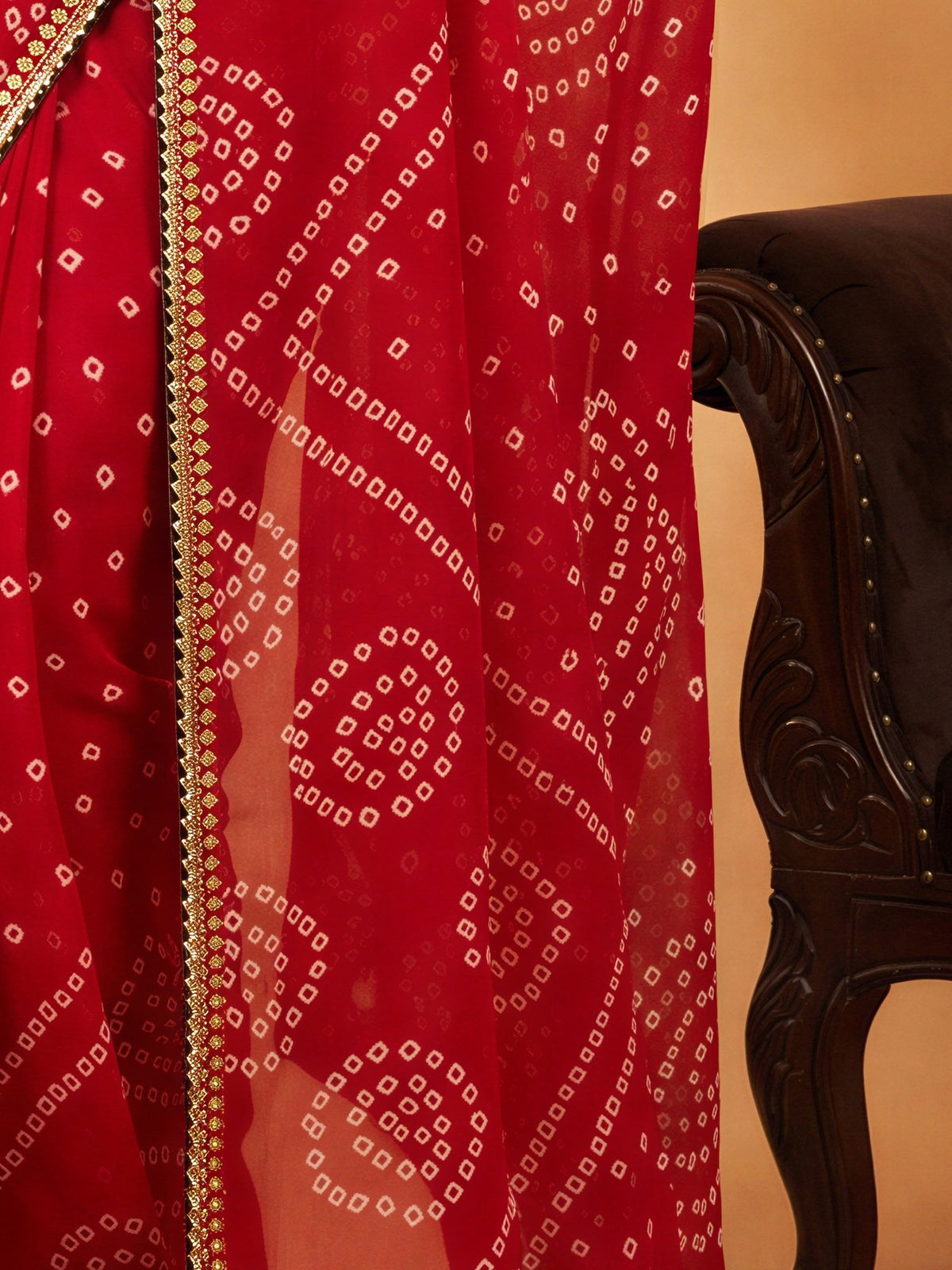 Pallu detail of red georgette saree showing bandhani tie-dye dot work and embellished border