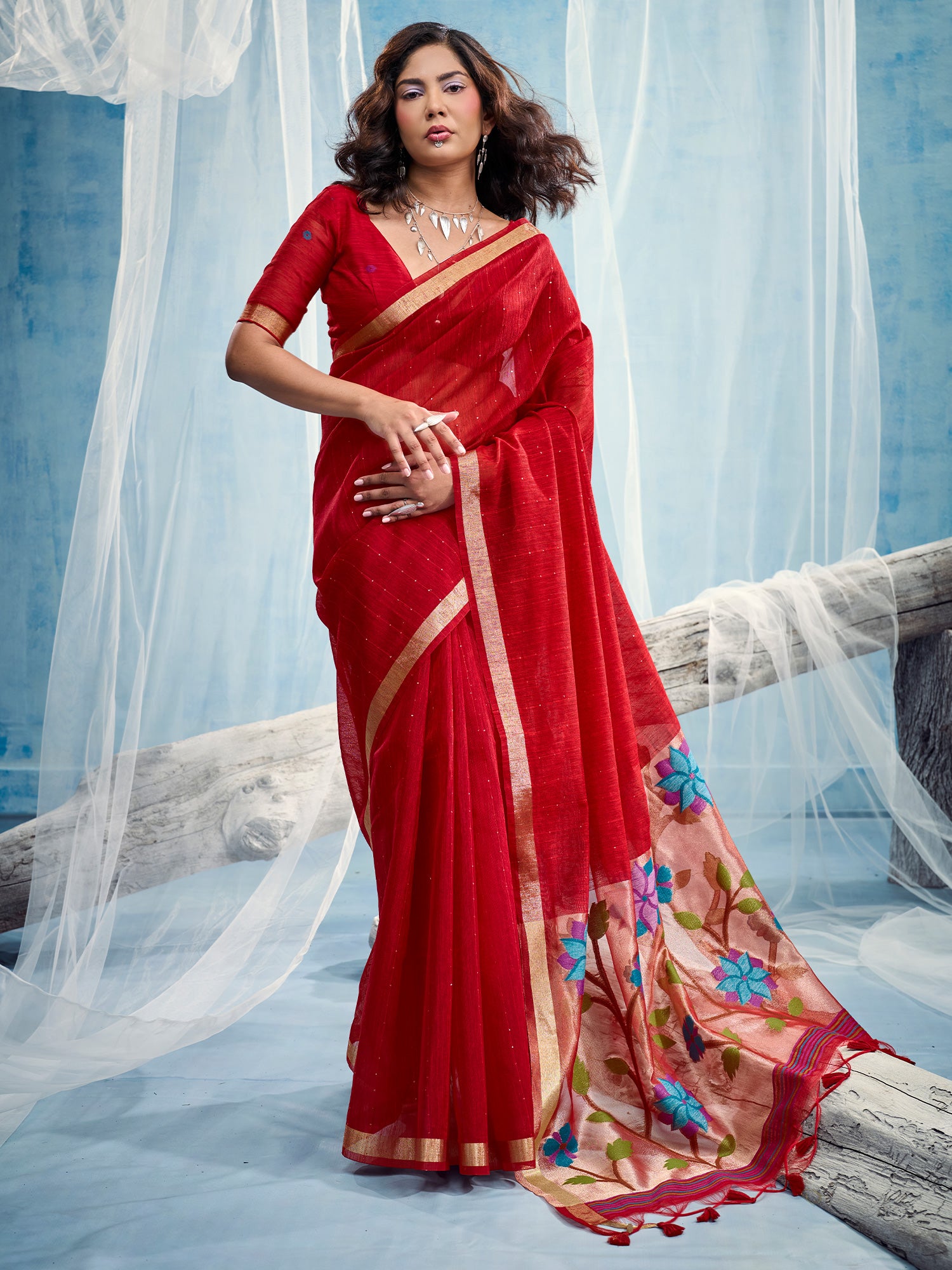 Woman wearing red muga silk saree with clean solid-tone finish and red blouse