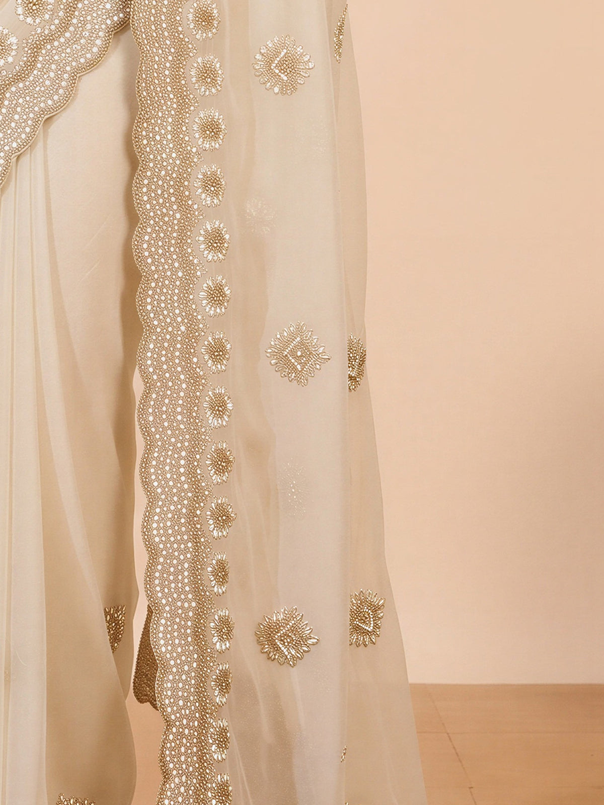 Pallu detail of off white georgette saree showing embroidered motif work and embroidered border