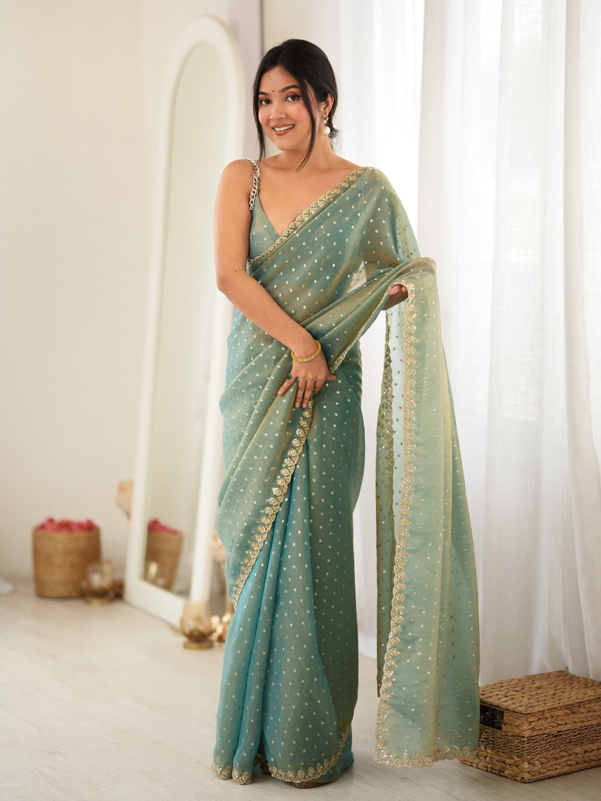Woman wearing light blue georgette saree with zari butta (metallic motif) work and light blue blouse