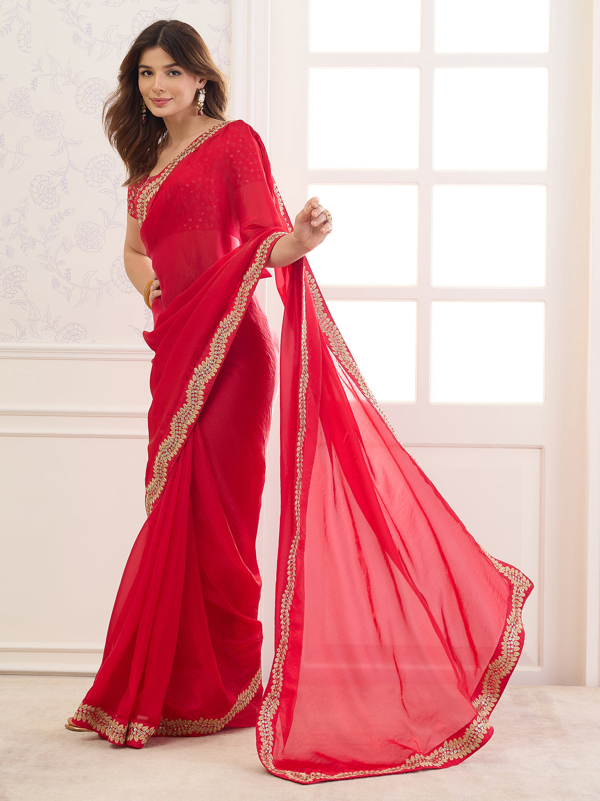 Woman wearing red satin saree with clean solid-tone finish and red blouse