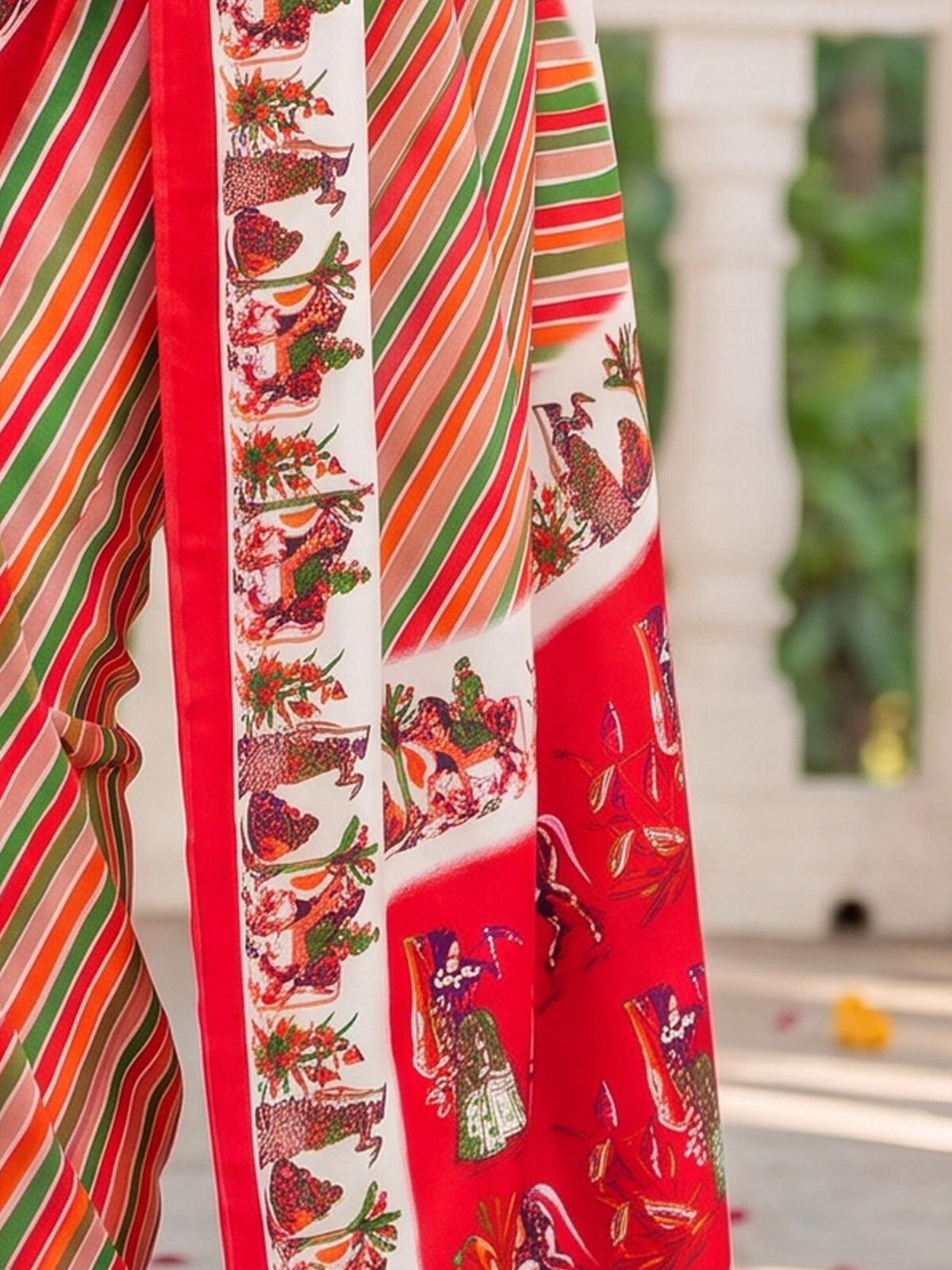 Pallu detail of red crepe saree showing striped pattern design and printed border