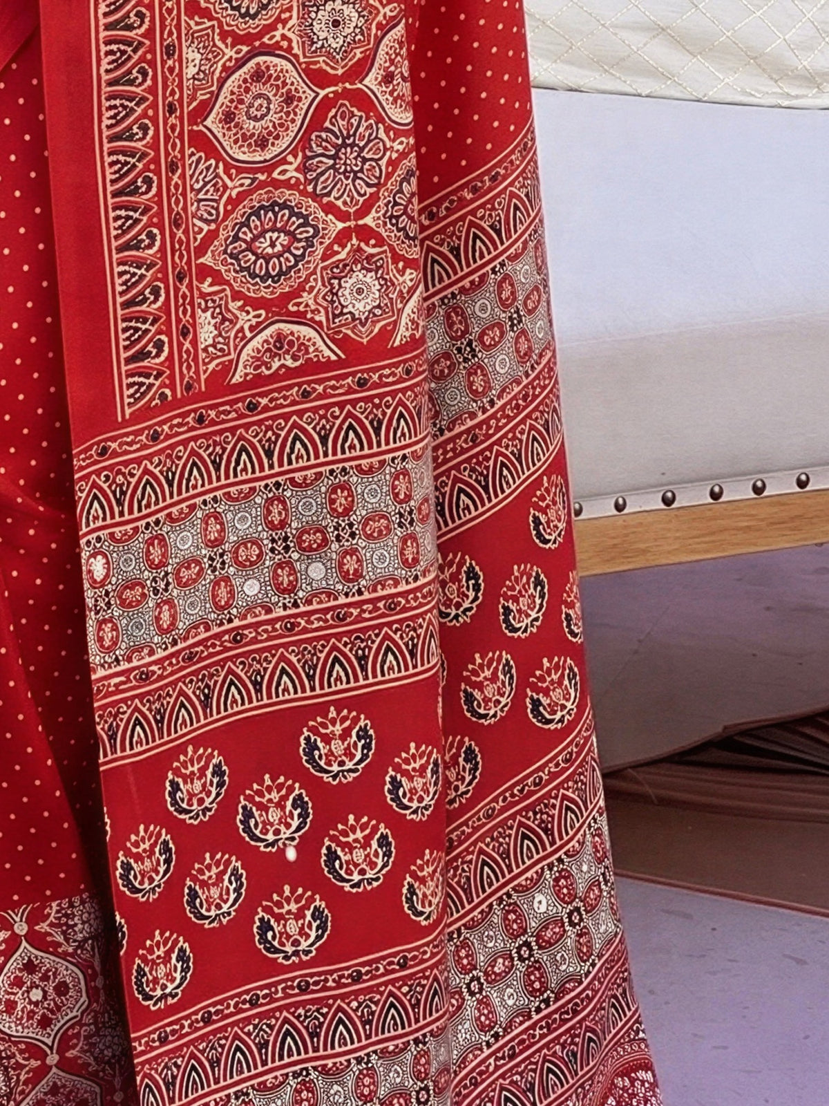 Pallu detail of red satin saree showing ajrak block-print motif work and printed border