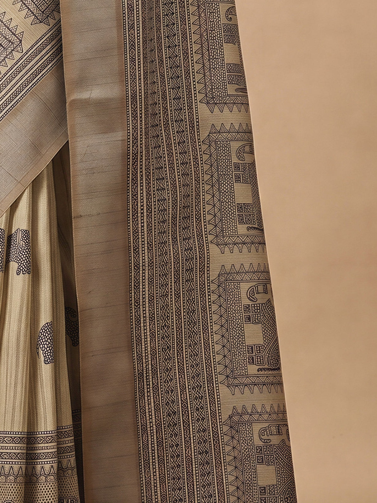 Pallu detail of cream satin silk saree showing hand block-printed motifs and zari border