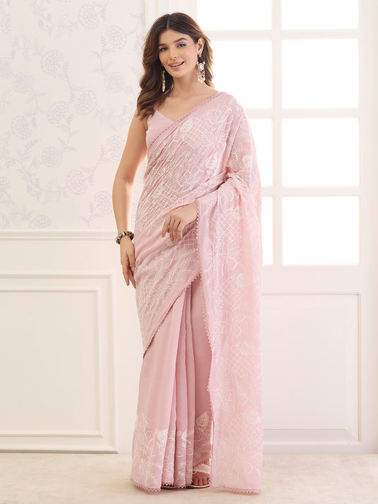 Woman wearing pink mulmul saree with embroidered motif work and pink blouse