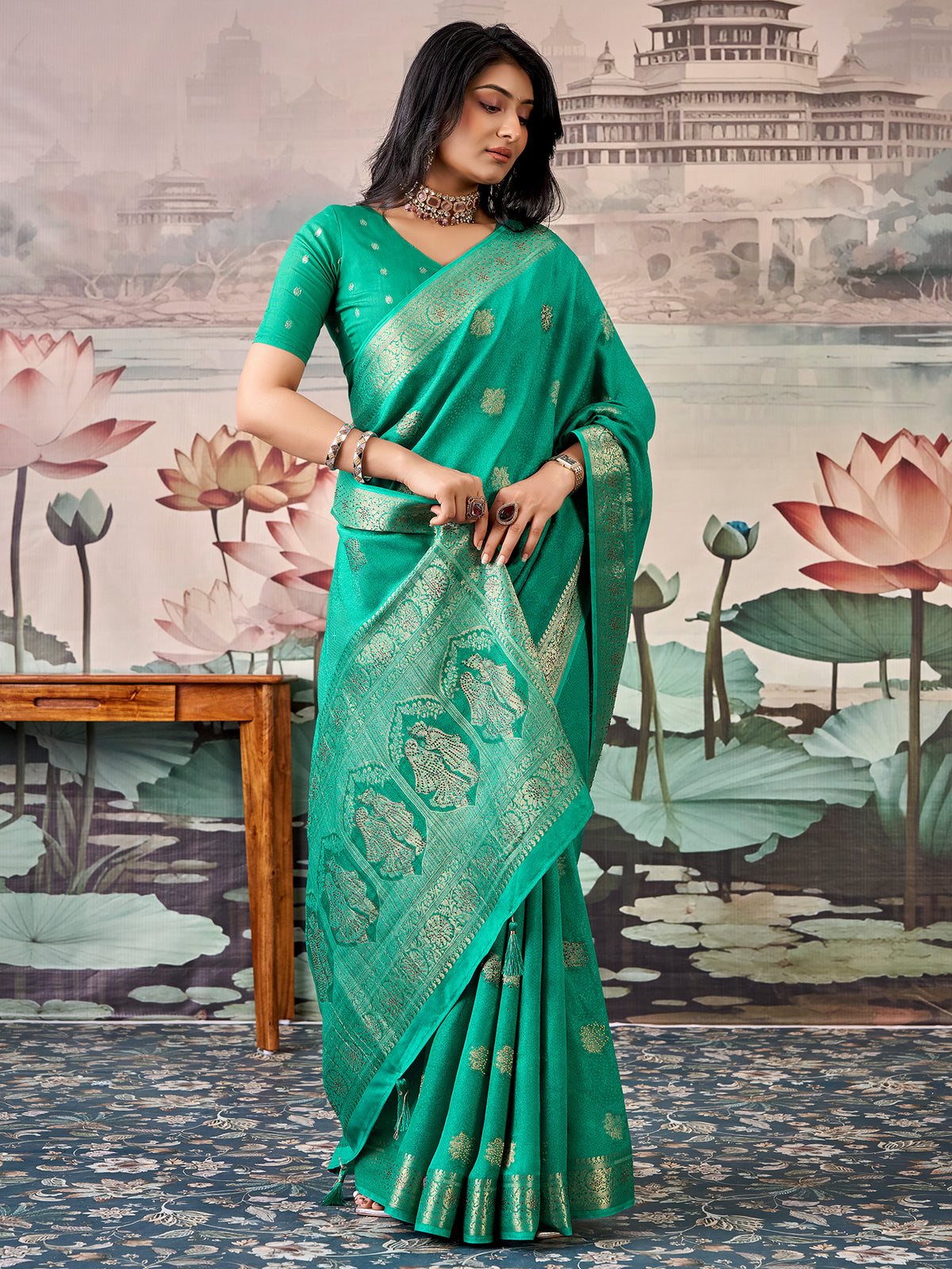 Woman wearing teal green georgette saree with zari butta (metallic motif) work and teal green blouse