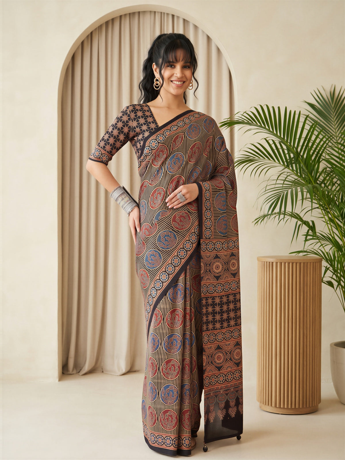 Woman wearing black silk blend saree with traditional indian motif work and black blouse