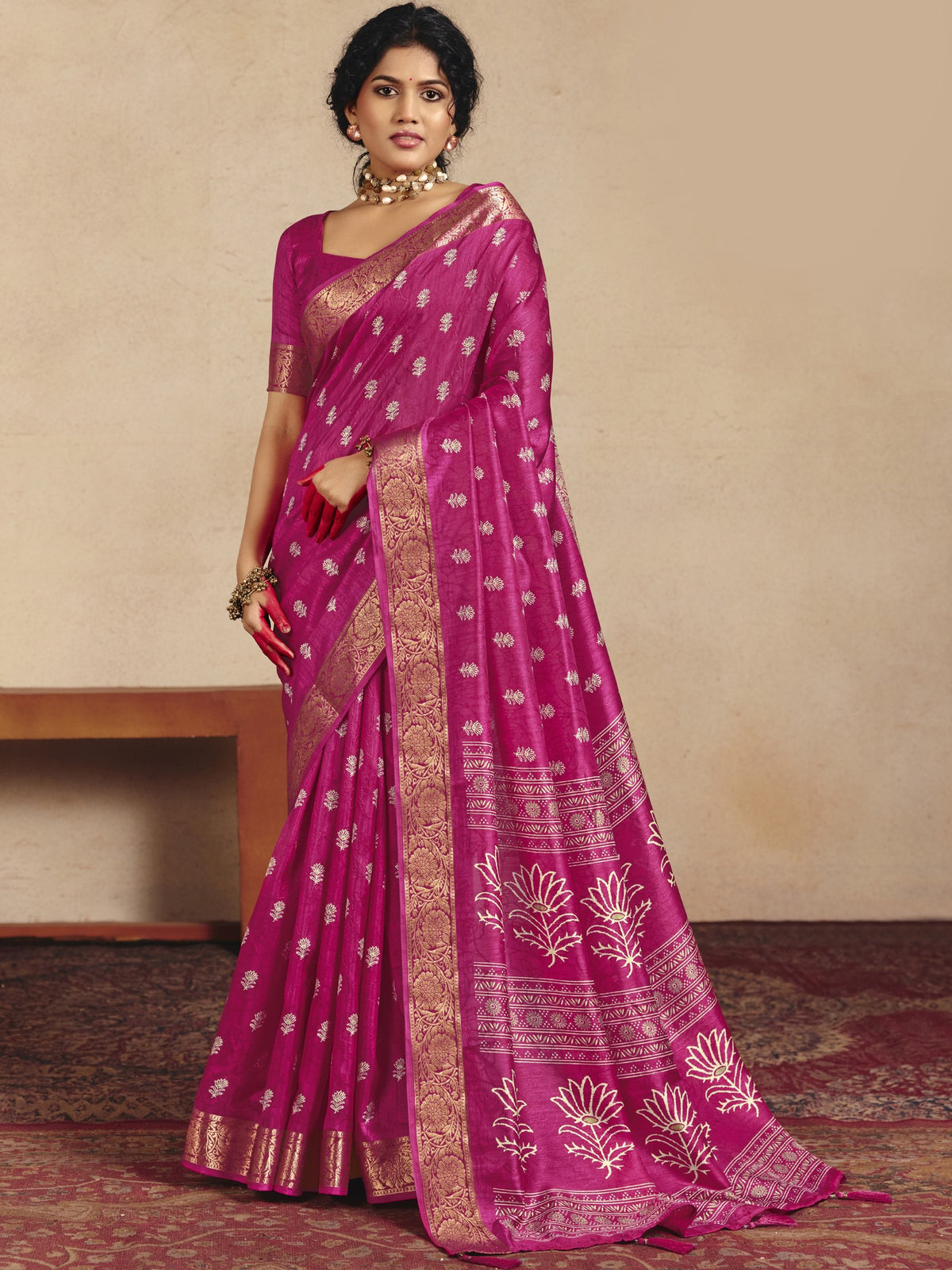 Woman wearing magenta tussar silk saree with traditional indian motif work and magenta blouse