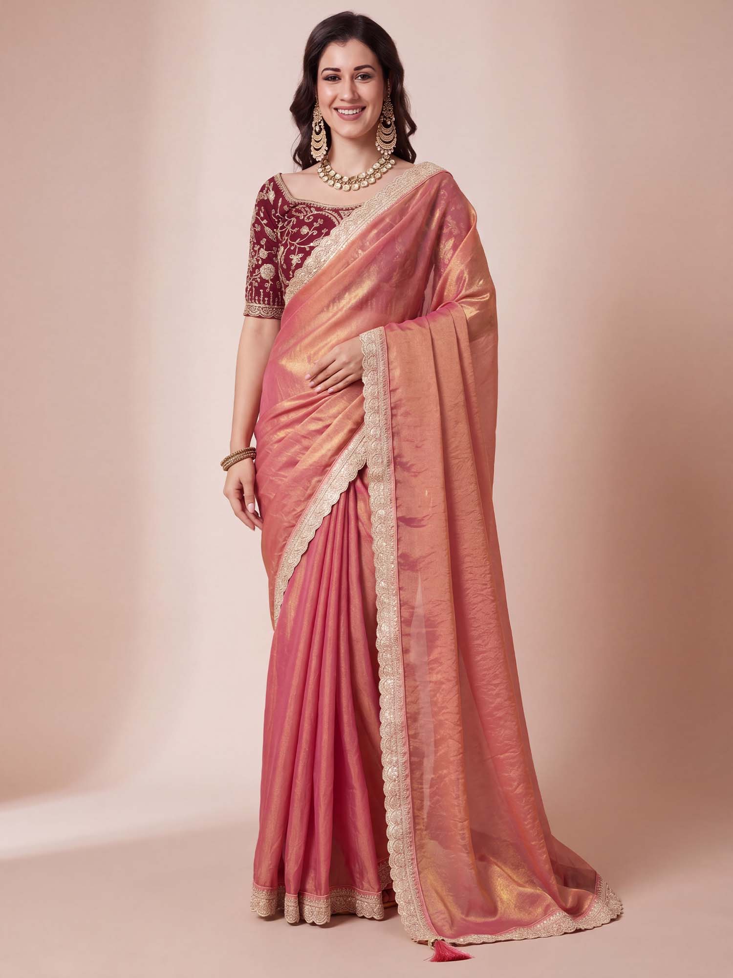 Woman wearing rose gold organza saree with clean solid-tone finish and maroon blouse