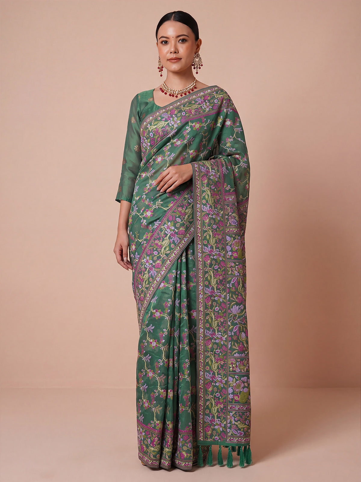 Woman wearing tealgreen organza saree with botanical floral and leaf design and teal green blouse