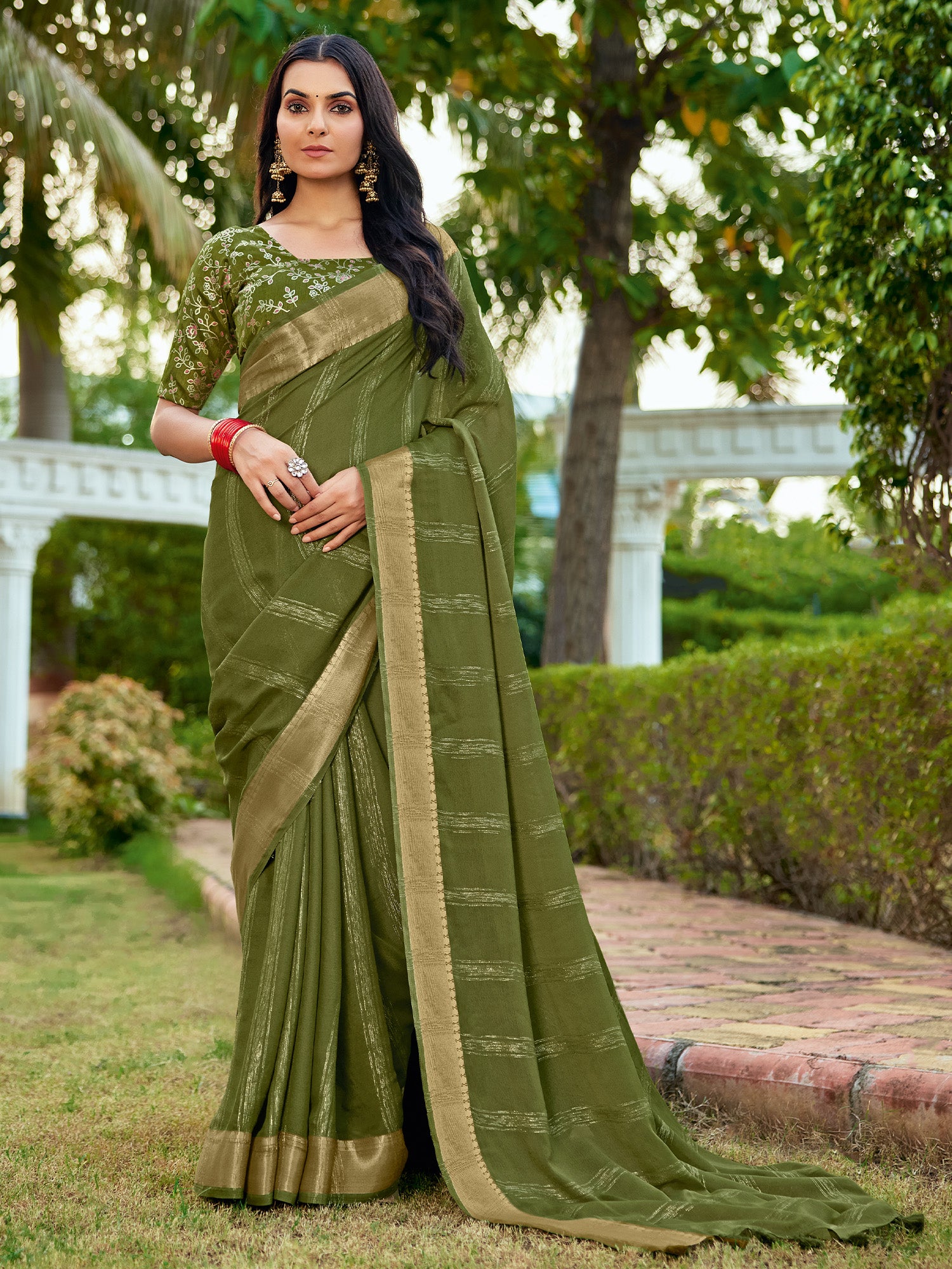 Woman wearing green georgette saree with striped pattern design and green blouse