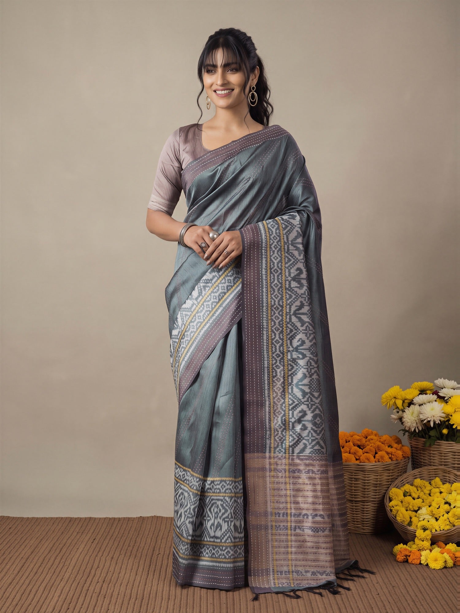 Woman wearing grey silk cotton saree with ikat resist-dyed pattern and mauve blouse