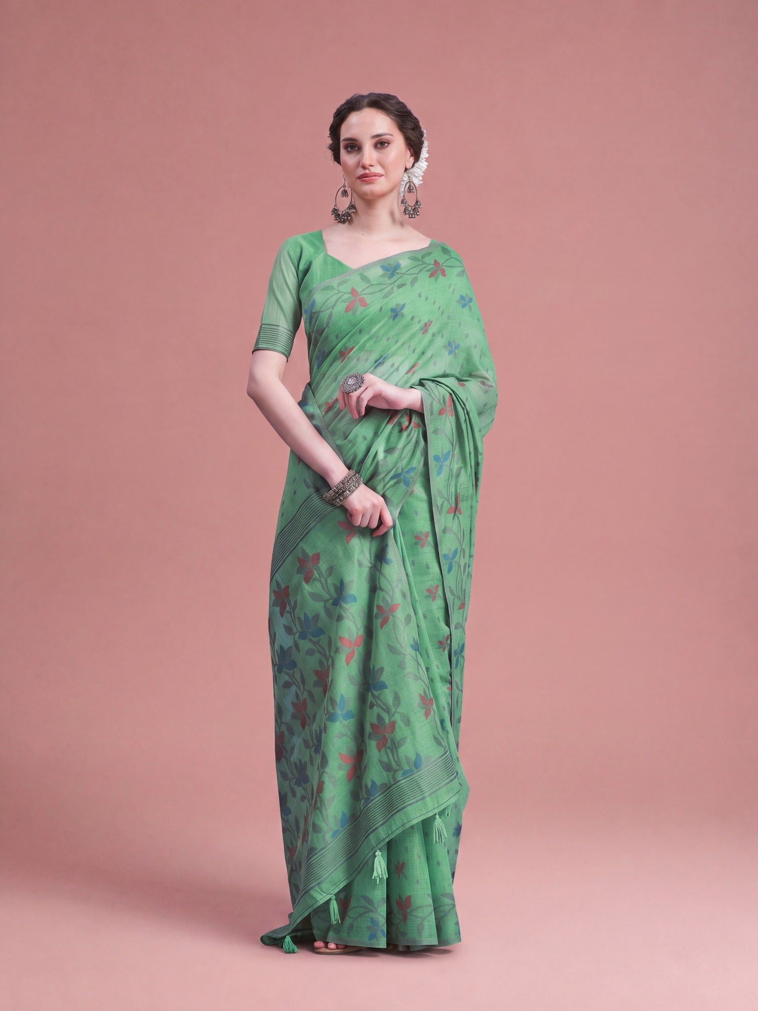 Woman wearing light green linen saree with all-over floral design and light green blouse