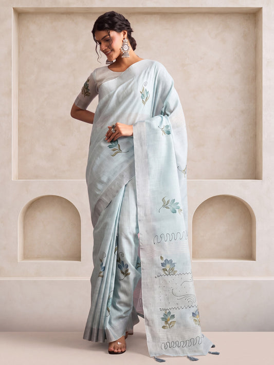 Woman wearing light blue linen saree with traditional indian motif work and light blue blouse
