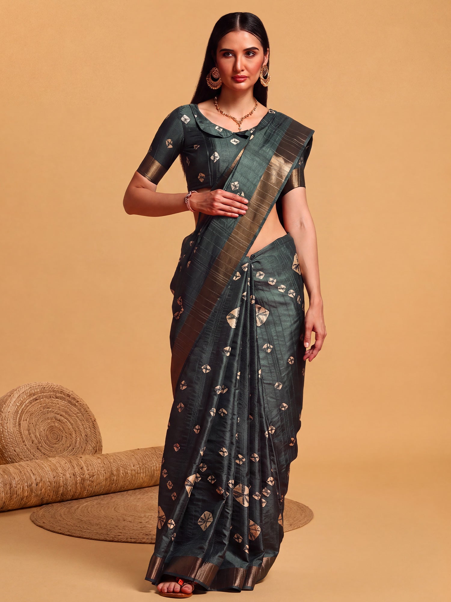 Woman wearing teal green silk blend saree with bandhani tie-dye dot work and teal green blouse