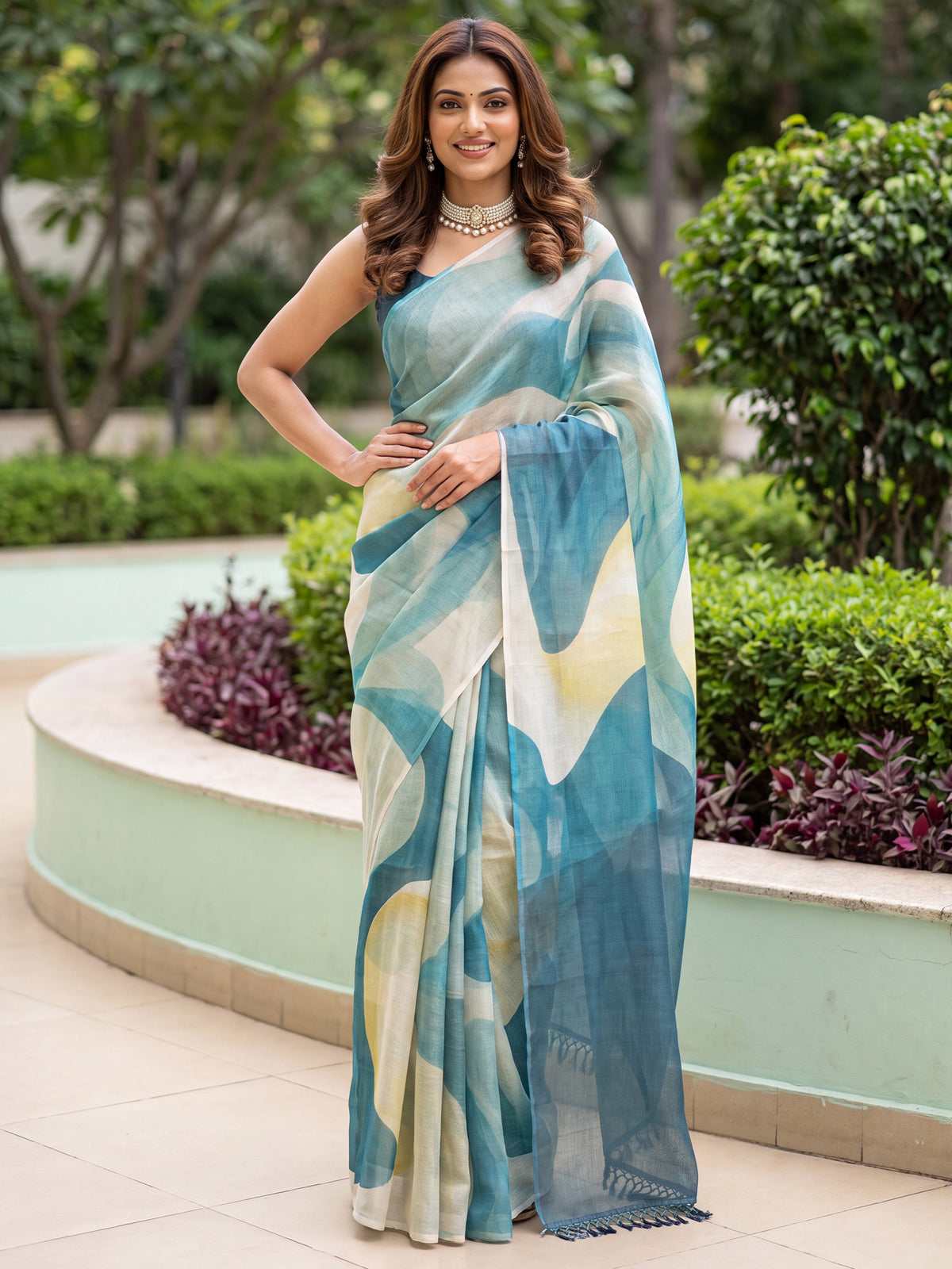 Woman wearing teal blue cotton silk saree with abstract contemporary design and teal blue blouse