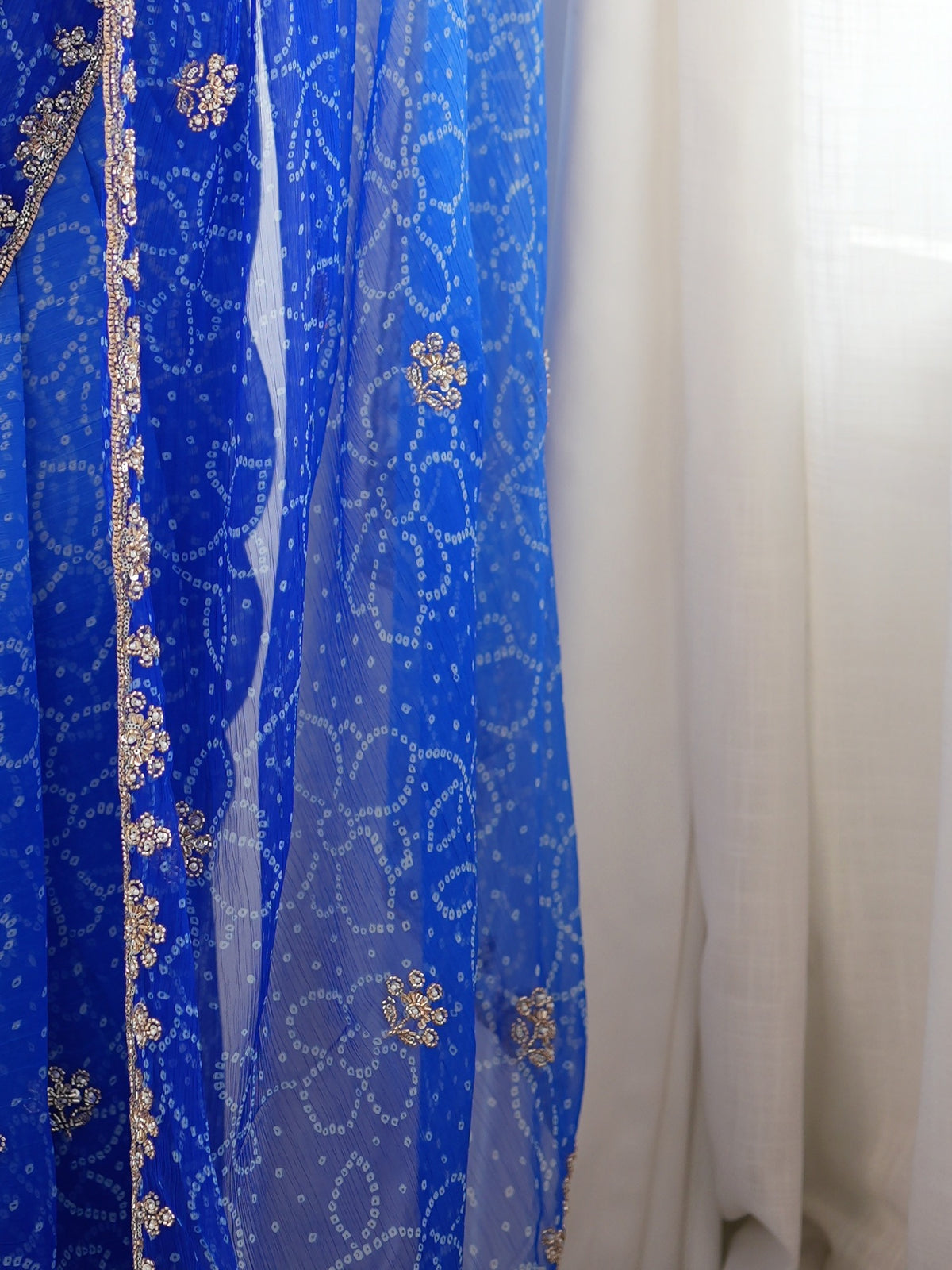 Pallu detail of blue georgette saree showing bandhani tie-dye dot work and embellished border