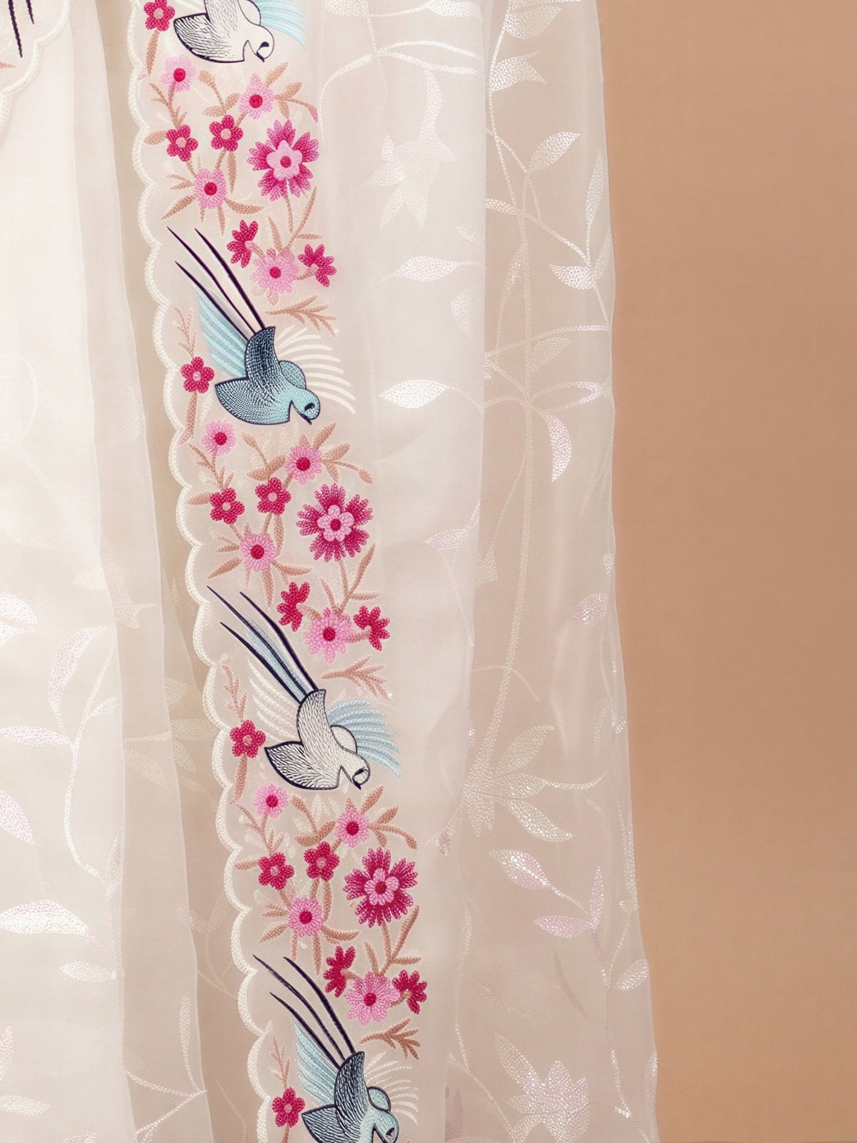 Pallu detail of white organza saree showing embroidered motif work and embroidered border