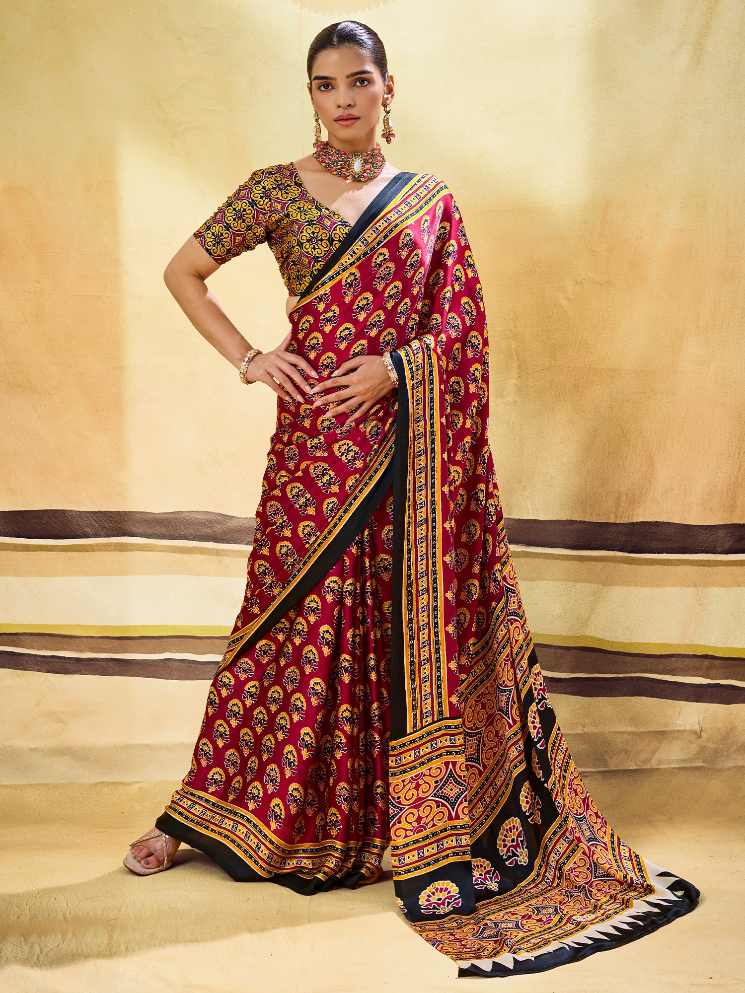 Woman wearing maroon satin saree with ajrak block-print motif work and mustard blouse