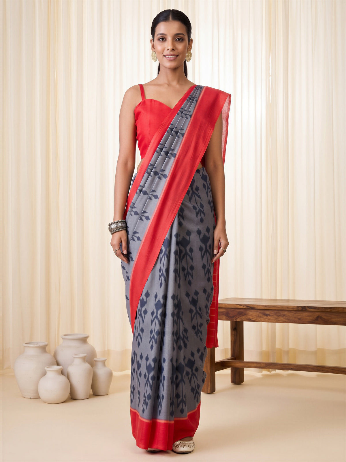 Woman wearing grey cotton blend saree with ikat resist-dyed pattern and red blouse