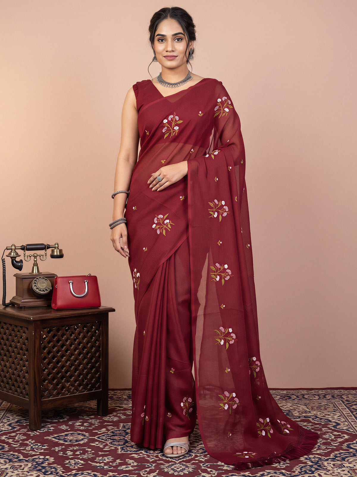 Woman wearing maroon kota doria cotton saree with embroidered motif work and maroon blouse