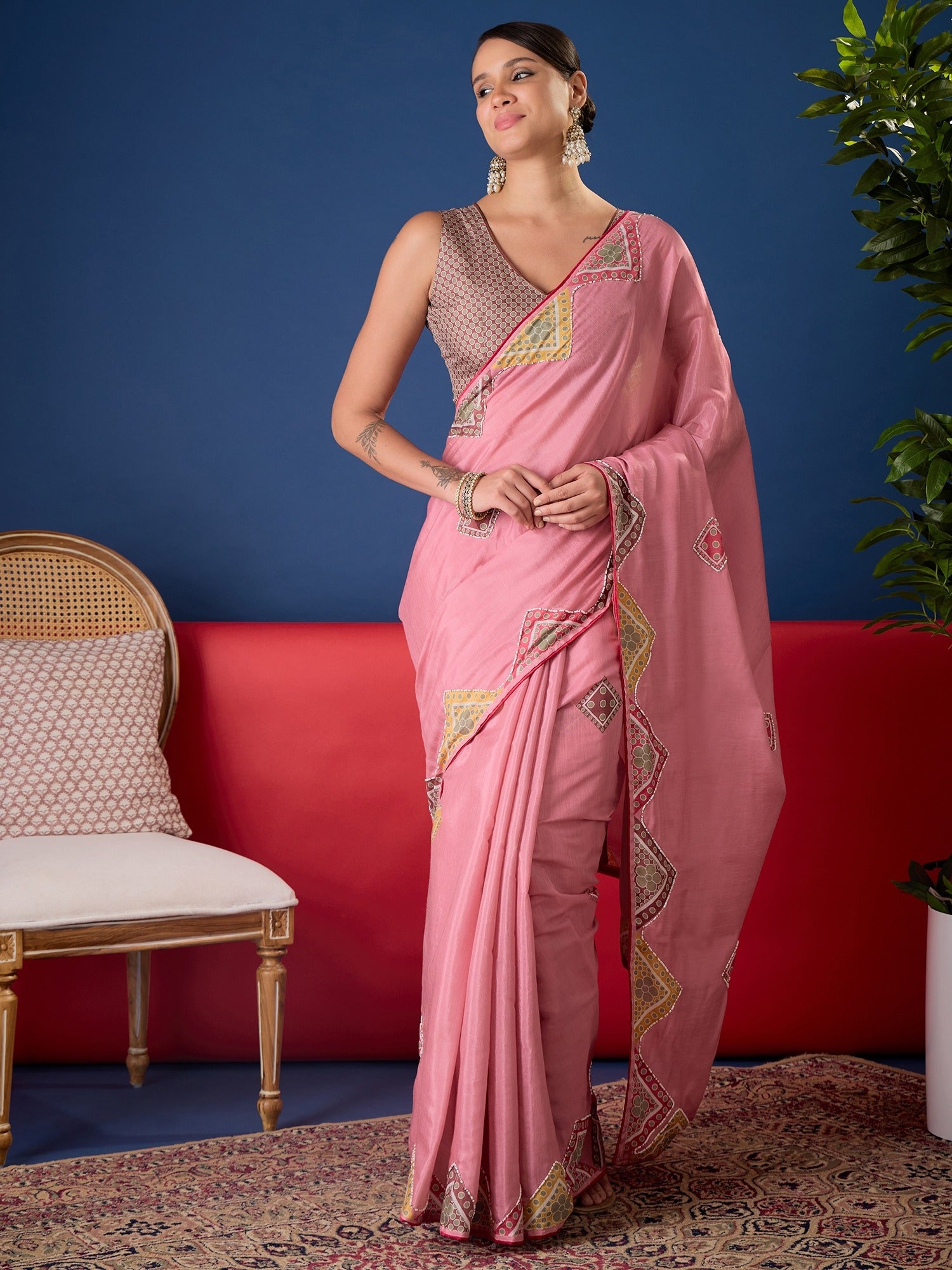 Woman wearing pink silk cotton saree with traditional indian motif work and multicolored blouse