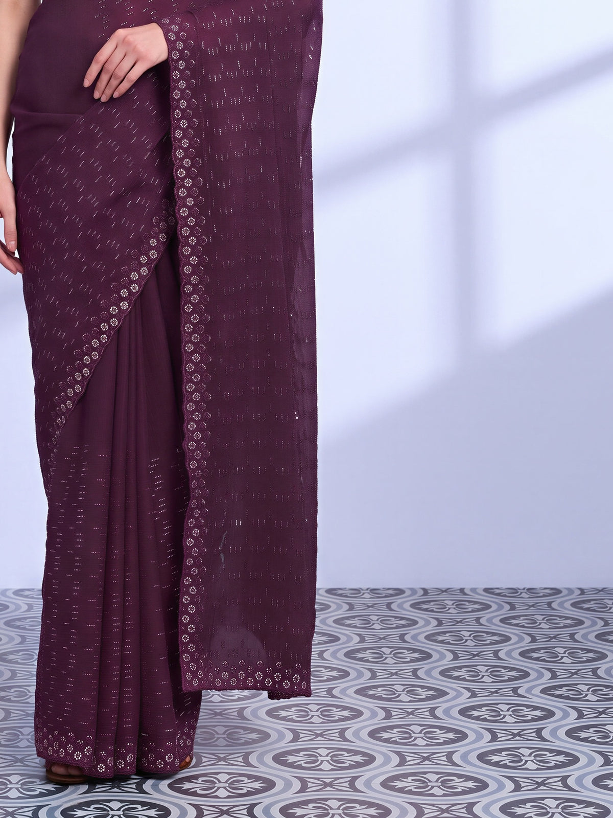 Pallu detail of red tissue saree showing ornamented surface design and embellished border