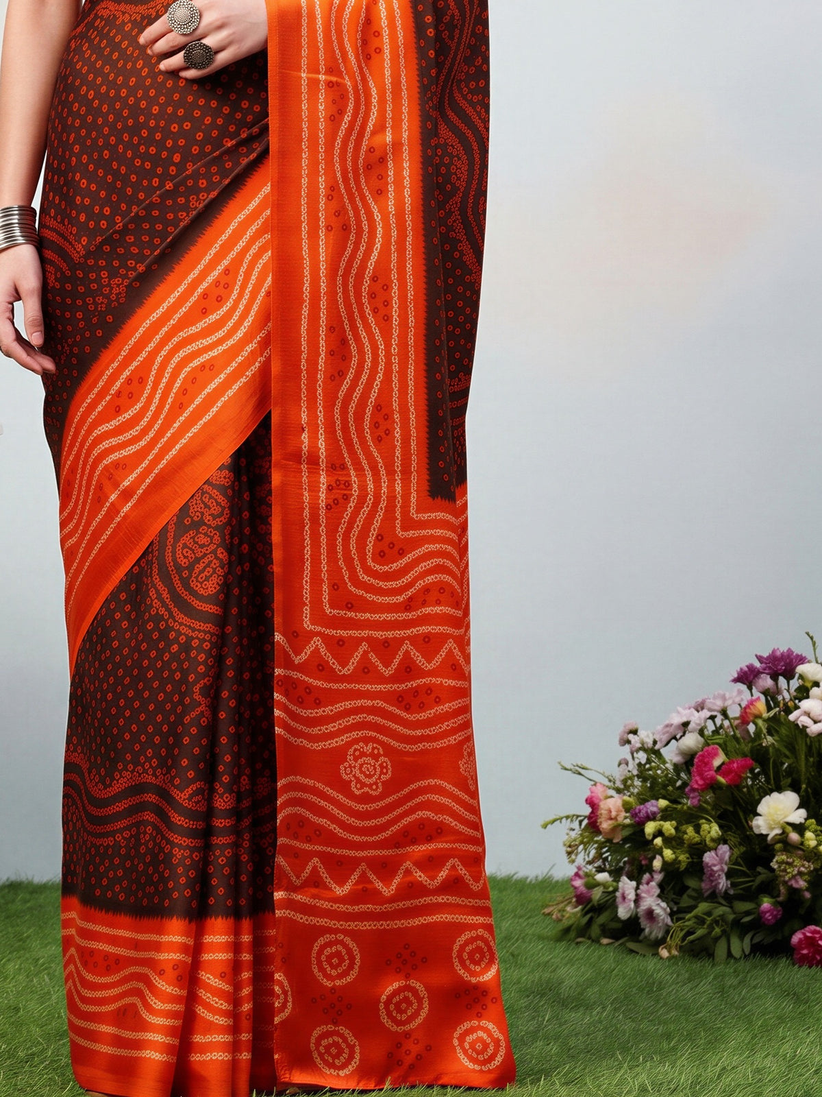 Pallu detail of brown satin silk saree showing bandhani tie-dye dot work and printed border