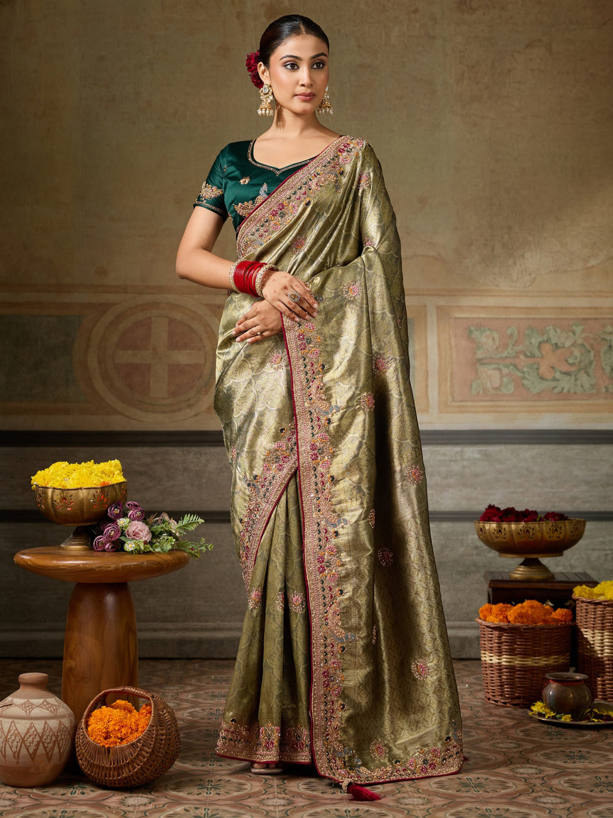 Woman wearing olive silk blend saree with ornamented surface design and dark green blouse