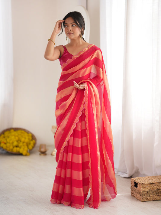 Woman wearing pink satin saree with striped pattern design and pink blouse