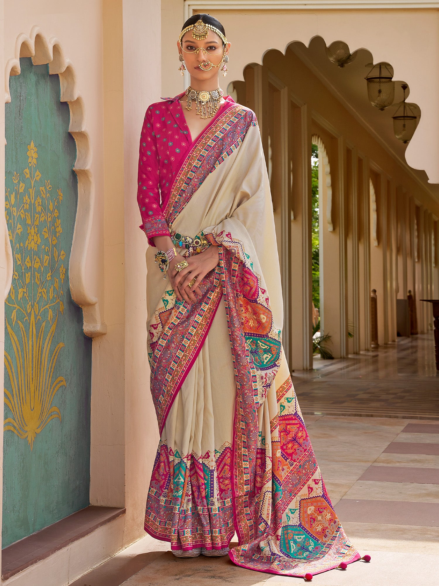 Woman wearing beige silk blend saree with kalamkari narrative motif work and pink blouse