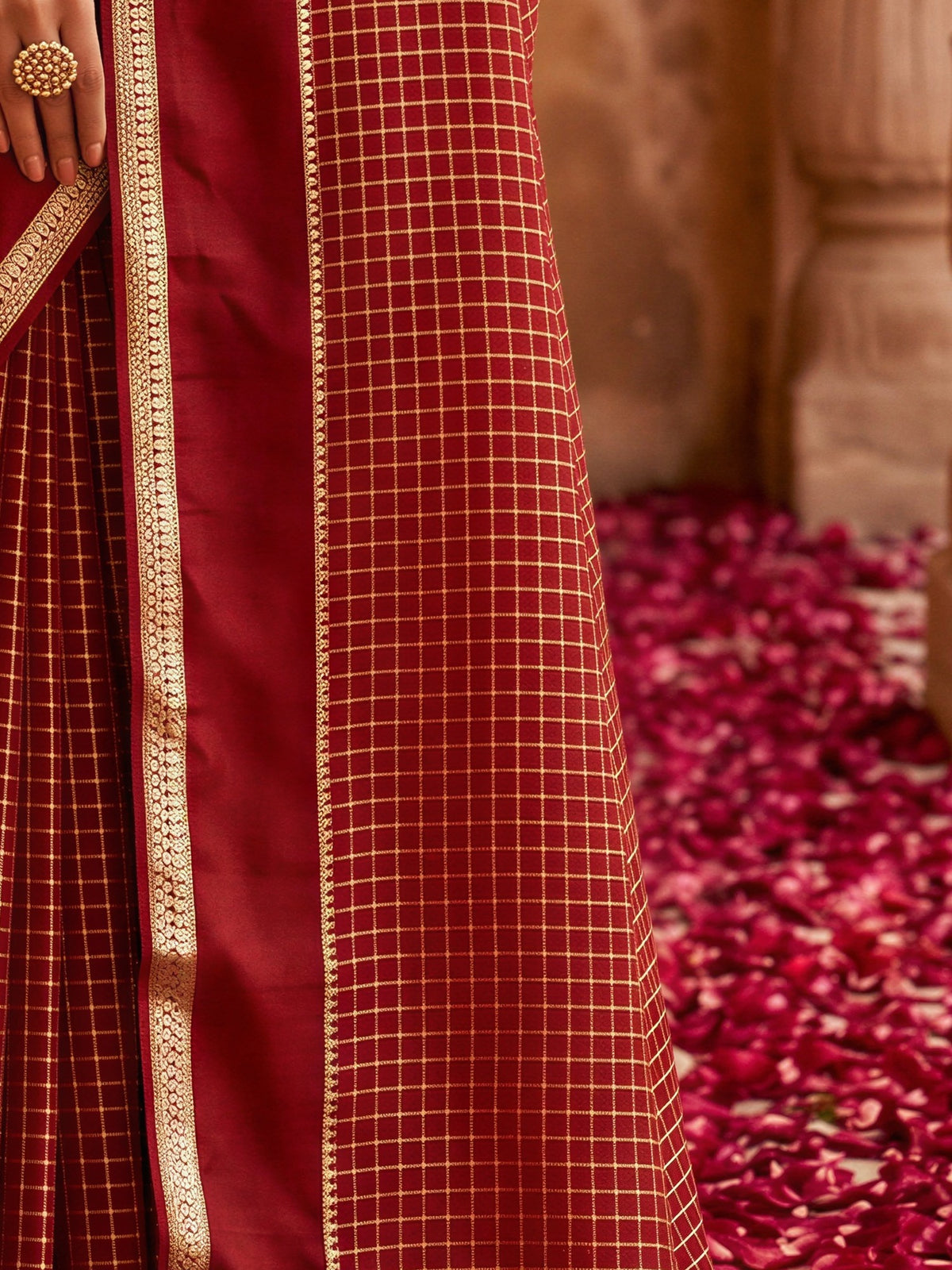 Pallu detail of maroon viscose saree showing checked pattern design and zari border