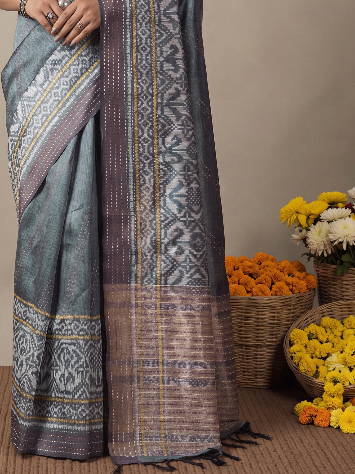 Pallu detail of grey silk cotton saree showing ikat resist-dyed pattern and embroidered border
