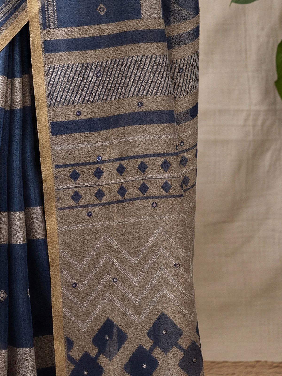 Pallu detail of navy blue linen blend saree showing traditional indian motif work and printed border