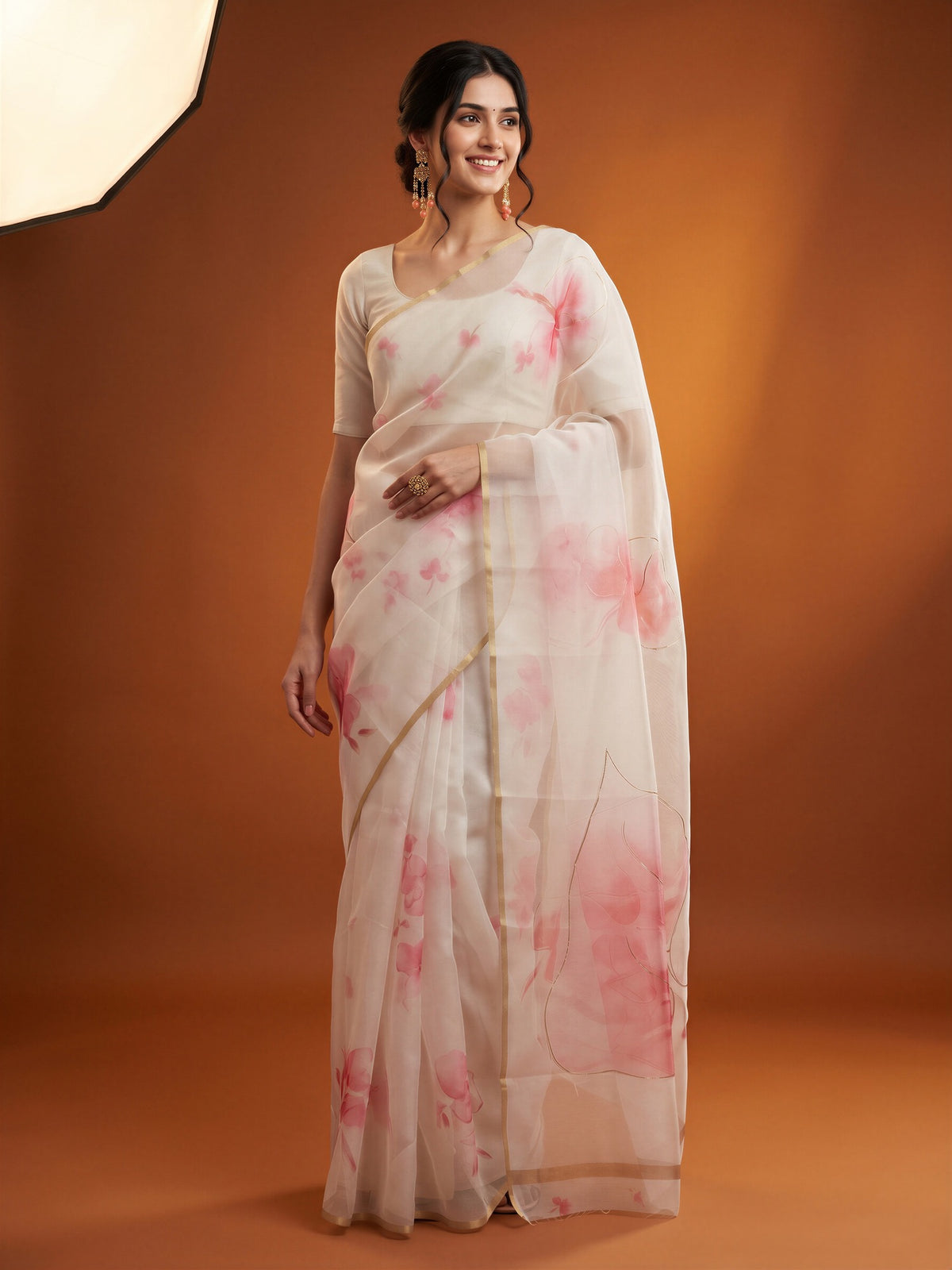 Woman wearing white organza saree with abstract contemporary design and pink blouse