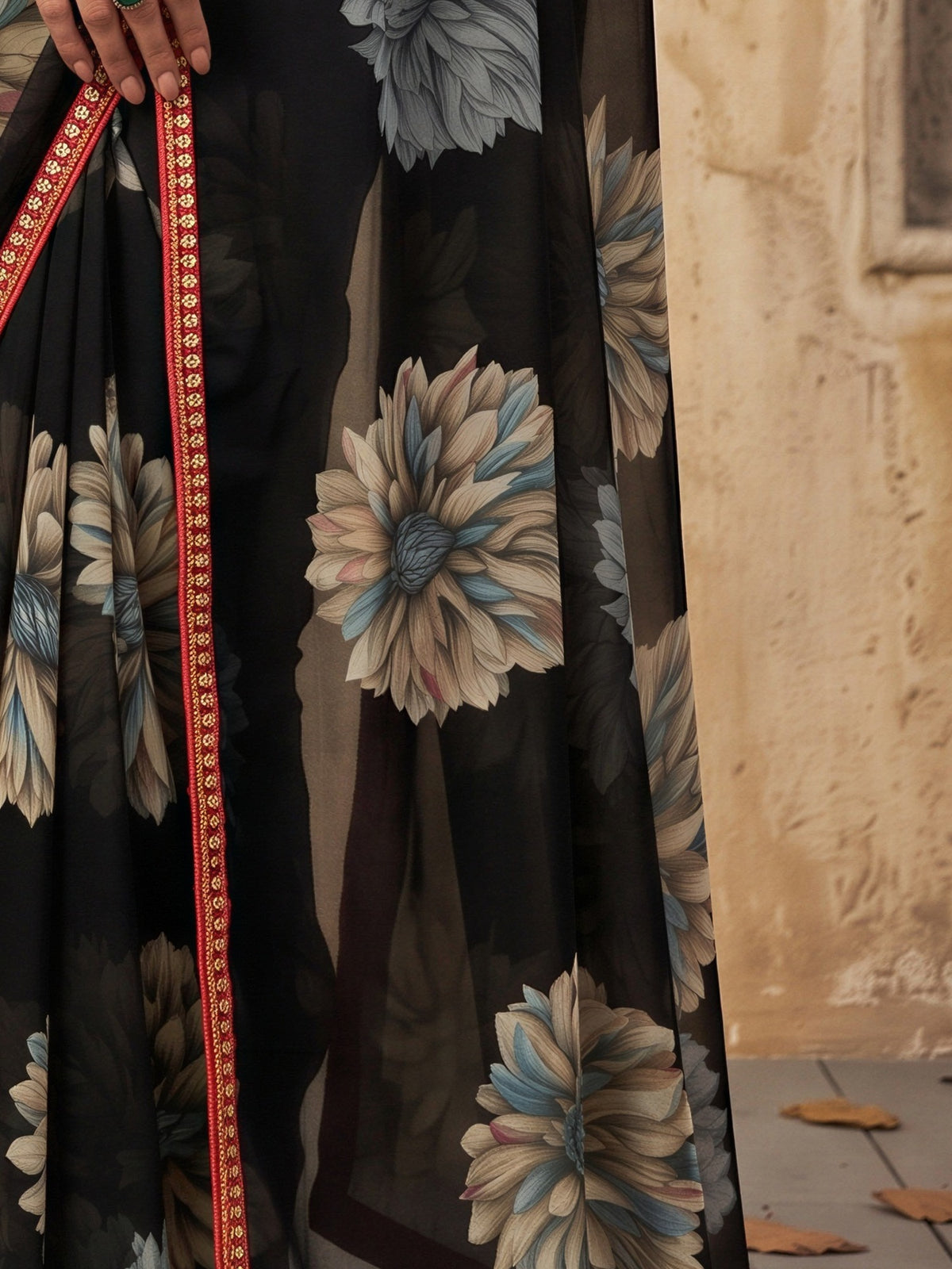 Pallu detail of black georgette saree showing all-over floral design and embellished border