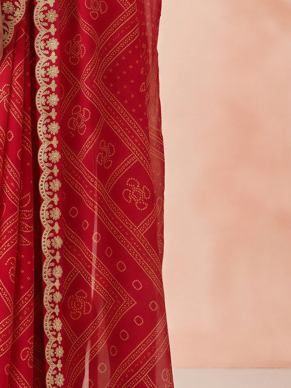 Pallu detail of red georgette saree showing bandhani tie-dye dot work and embellished border