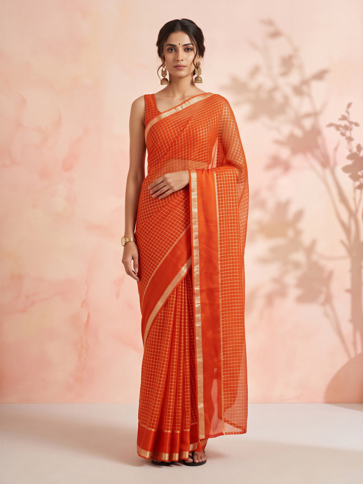 Woman wearing orange viscose saree with checked pattern design and orange blouse