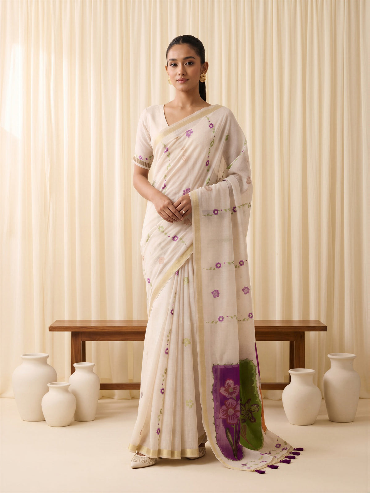 Woman wearing off white cotton blend saree with traditional indian motif work and off white blouse