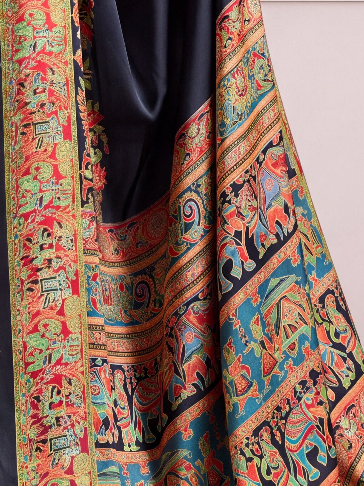 Pallu detail of black satin saree showing madhubani folk-art motifs and printed border