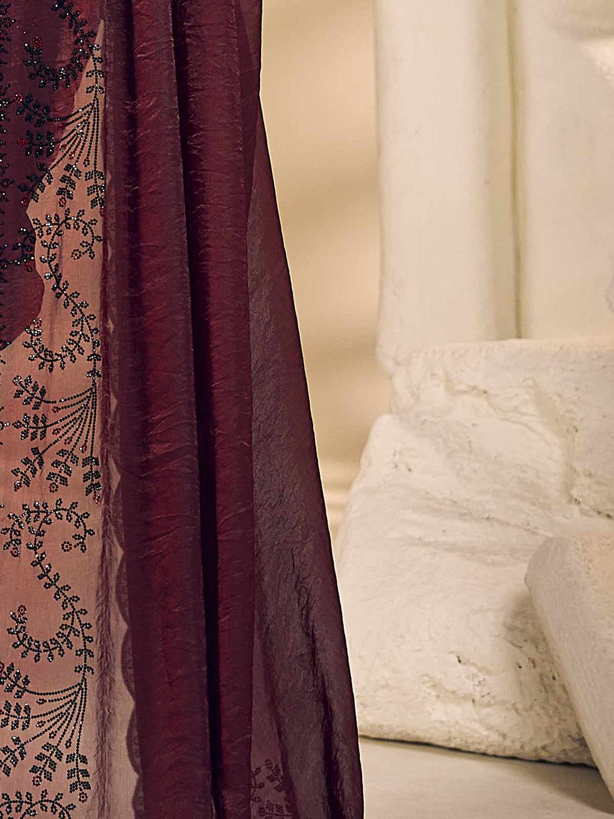 Pallu detail of maroon satin silk saree showing ornamented surface design and embellished border