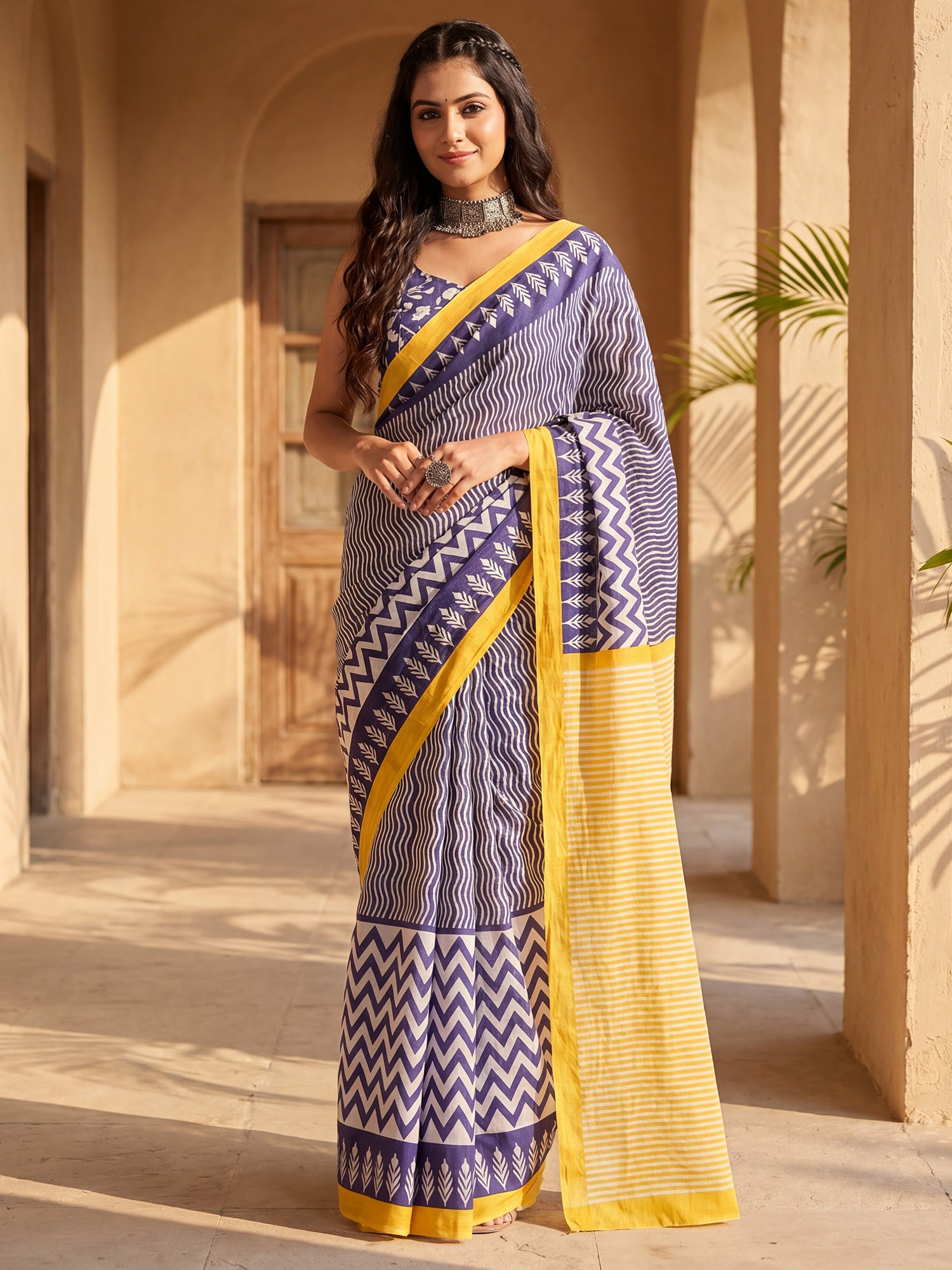 Woman wearing blue cotton blend saree with geometric pattern design and blue blouse