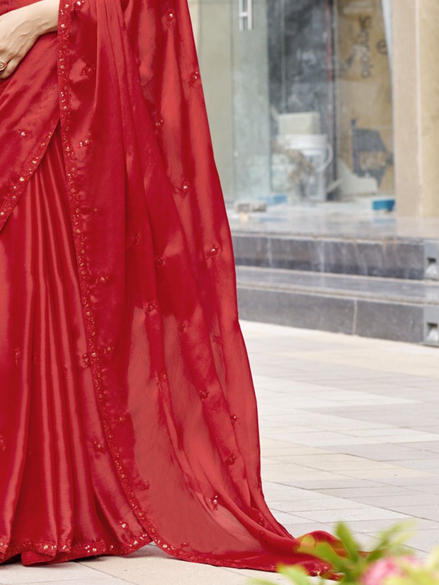 Pallu detail of red satin silk saree showing ornamented surface design and embellished border