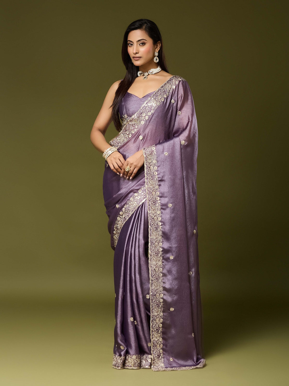 Woman wearing lavender chinnon saree with embroidered motif work and lavender blouse