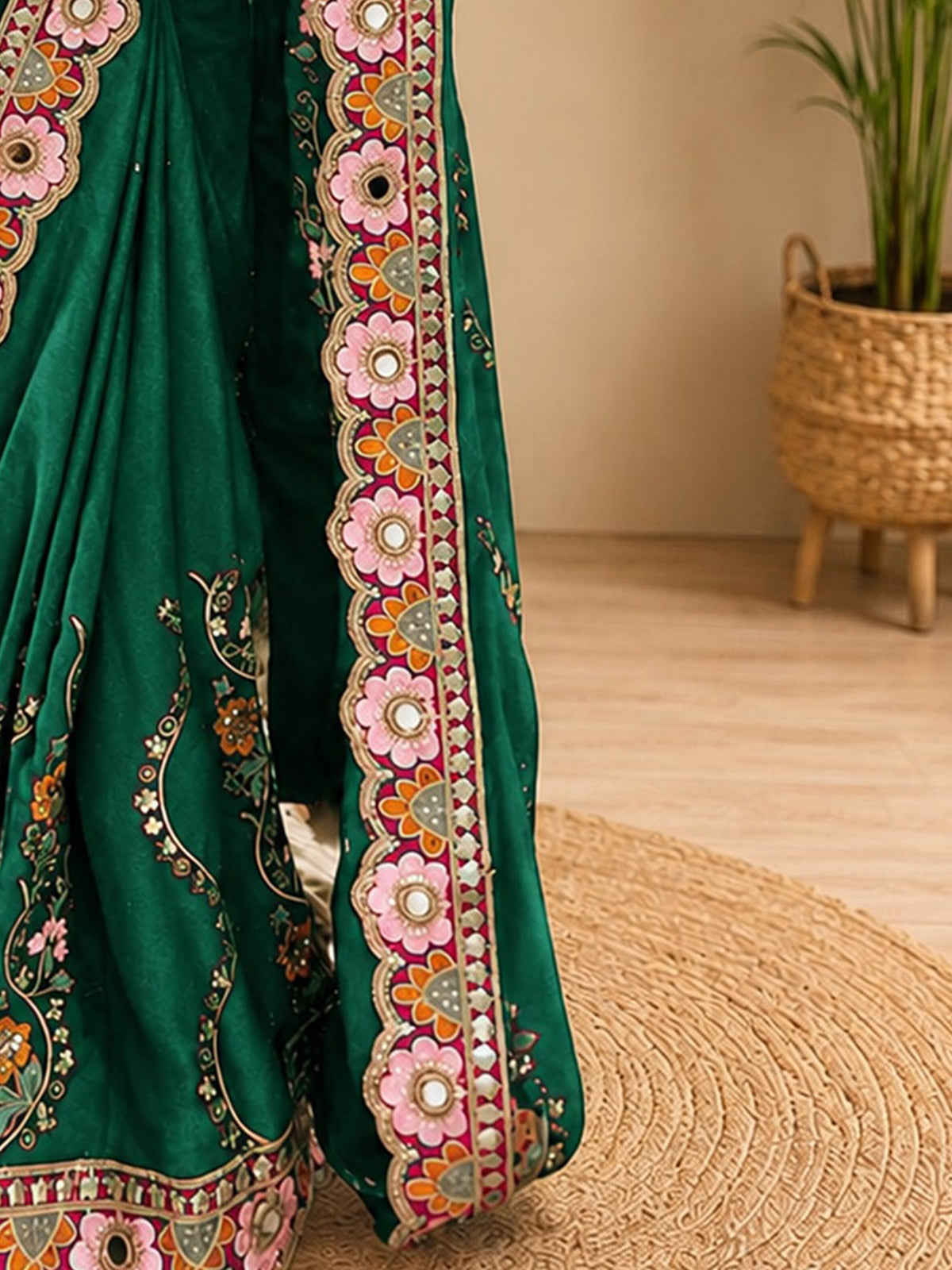 Pallu detail of green pure georgette saree showing all-over floral design and embellished border